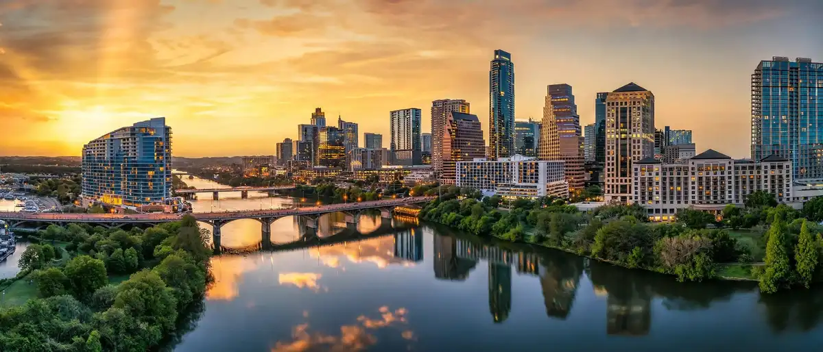 Best hotels in Austin – downtown hotel towers reflected in Lady Bird Lake at sunset