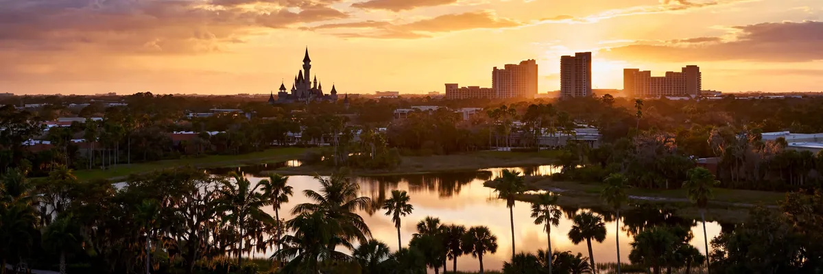 Best hotels in Orlando – theme park resort district at golden hour with castle silhouette and palm trees